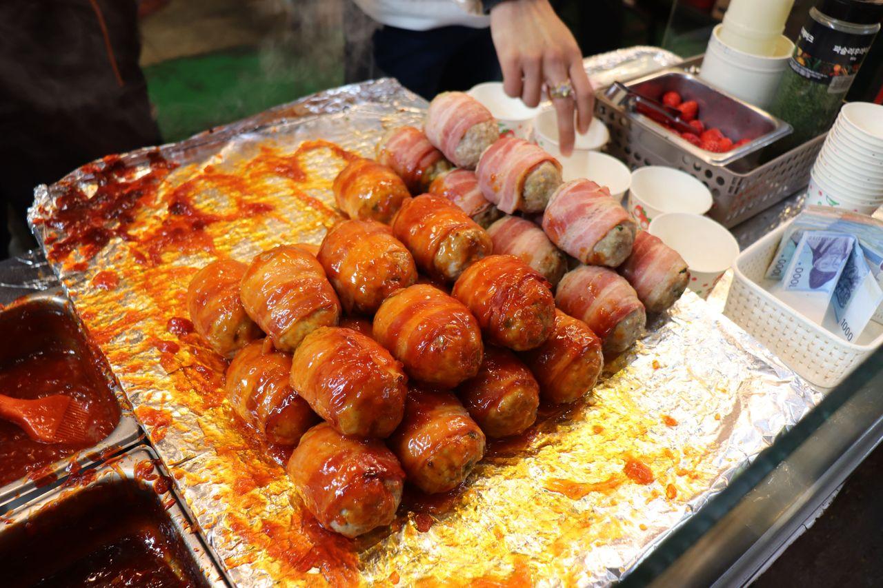 厚實的牛肉排正在烤盤上滋滋作響，吸引著顧客停足購買